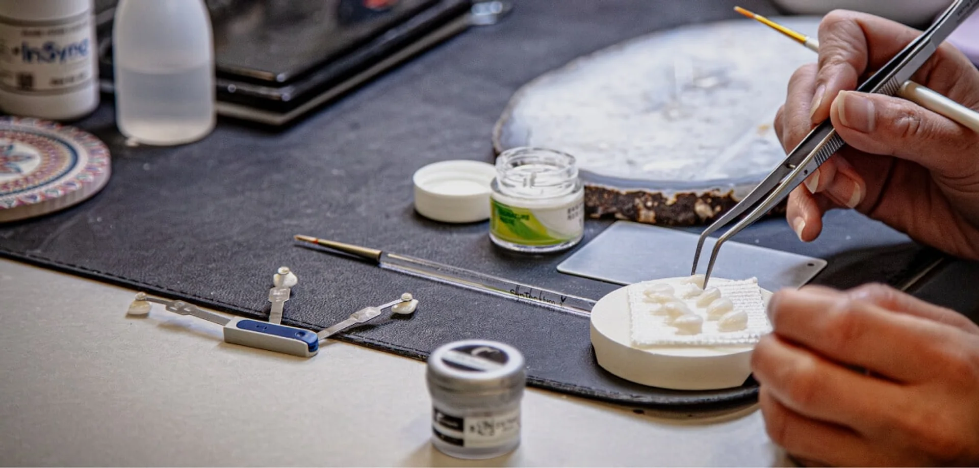 YM technician hand-finishing ceramic restorations at the bench