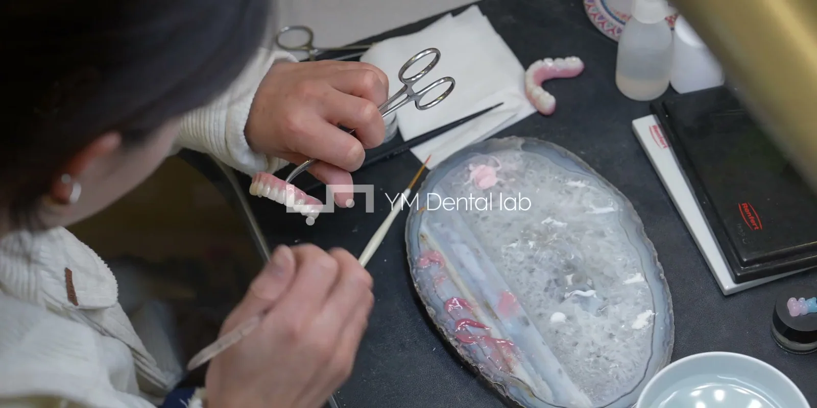 YM technicians hand-finishing ceramic restorations
